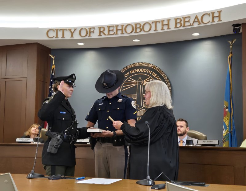 Ptlm. Kamryn Linsenbigler is sworn in by Alderman Court 37 Judge Renee L. Bennett, with Bethany Beach Police officer Gregory Contorno holding the Bible.
